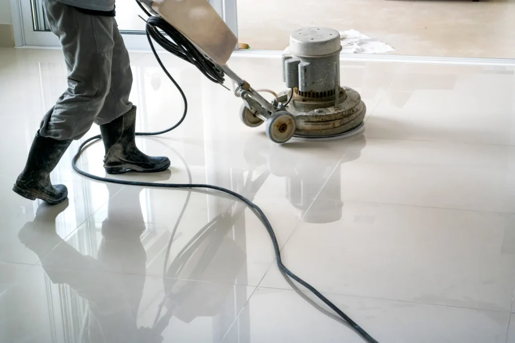 Worker using a floor polishing machine to clean and buff tiled flooring indoors