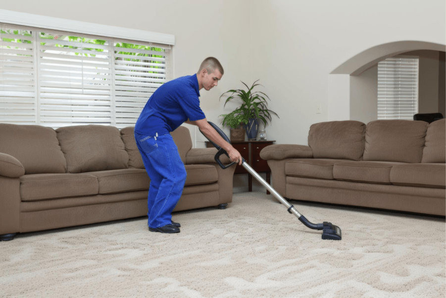 Technician cleaning carpet during an indoor property maintenance and cleaning services